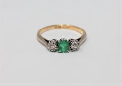 An 18ct gold two stone diamond and emerald ring, size L 1/2.