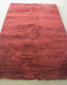 A hand knotted rug, shaggy maroon,