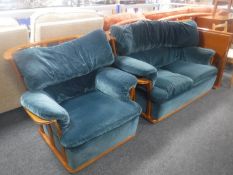 A 1970's teak framed two seater settee and armchair upholstered in blue fabric