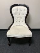 A Victorian style lady's chair upholstered in cream buttoned fabric