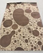 A hand-knotted rug on brown and cream ground,