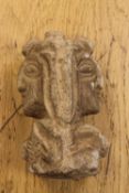 A medieval carved stone figure of Janus, the two-headed god, looking to the past and future,