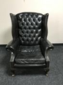 A buttoned leather wingback armchair