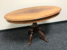 An oval mahogany coffee table on four-way pedestal