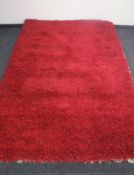 A hand knotted shaggy red rug,