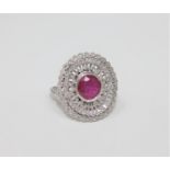 An 18ct white gold ruby and diamond ring, featuring one round cut natural ruby 1.