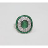 An 18ct white gold emerald and diamond ring featuring an oval cut emerald 2.