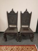 A pair of Anglo-Indian heavily carved hardwood side chairs, width 57 cm.
