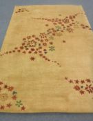 A hand-knotted rug of floral design on gold ground,