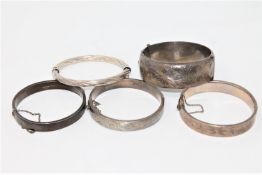 Five silver bangles CONDITION REPORT: The largest bangle and one of the medium sized