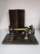 A vintage cased Singer sewing machine together with two poss sticks and tapestry footstool