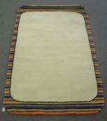 A hand knotted rug with striped border on cream ground,