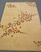 A hand-knotted rug of floral design on gold ground,