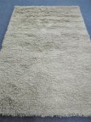 A hand knotted shaggy beige rug,