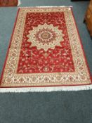 A Keshan carpet on red ground 230 cm x 150 cm
