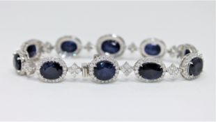 An 18ct white gold sapphire and diamond tennis bracelet featuring 10 oval cut Kashmiri sapphires 24.