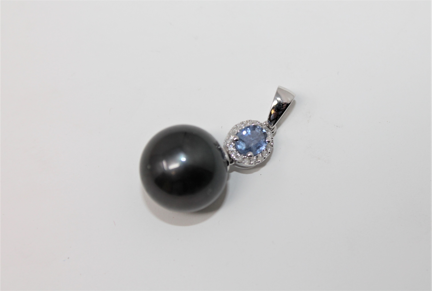 A 14ct white gold pearl and diamond pendant featuring one cultured Tahitian pearl with one oval cut