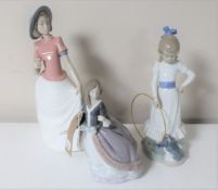 A Lladro figure of a lady in flowing dress (a/f) together with two Nao figures of a girl with a