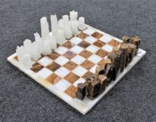 A two-tone onyx chess board and pieces