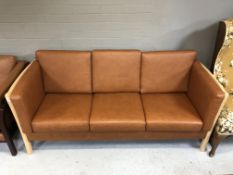 A late 20th century Danish beech framed three seater settee with brown leather cushions