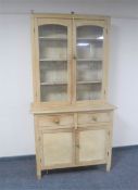 An antique pine glazed door kitchen dresser fitted with double door cupboard and two drawers