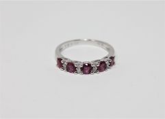 A 14ct white gold ruby and diamond ring featuring five round cut natural rubies 0.