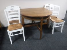 A pine flap sided kitchen table and four rush seated chairs