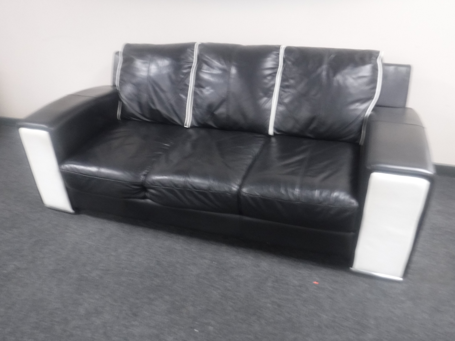 A three seater settee with matching two seater settee upholstered in a two-tone black and white