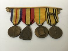 A group of four miniature WWI Belgian medals with ribbons