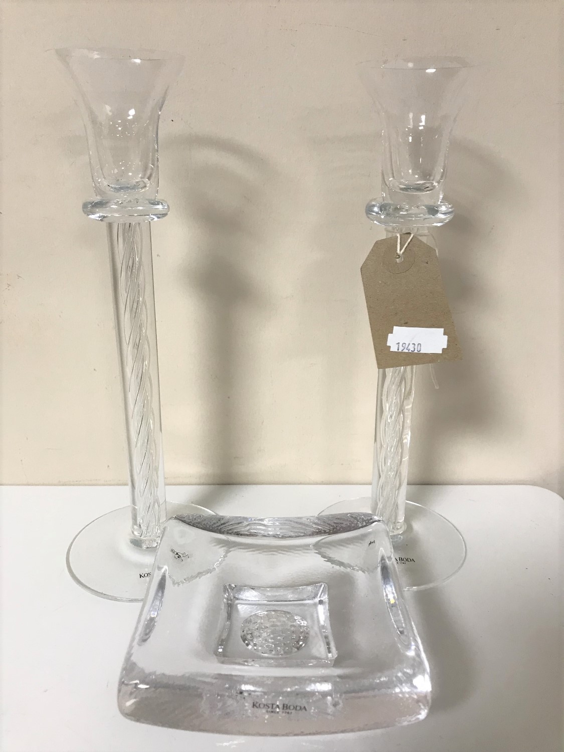 A pair of Kosta Boda twist stem glass candlesticks together with a glass ashtray