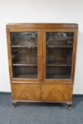 An early twentieth century walnut Queen Anne style double door bookcase fitted with cupboards