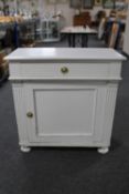 An early twentieth century painted pine cabinet fitted with a drawer