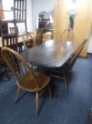 An Ercol refectory dining table together with a set of four high-back dining chairs