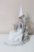 A Lladro figure of a lady seated with flower