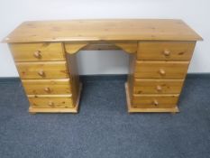 A pine knee hole dressing table fitted with eight drawers