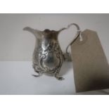 A miniature embossed silver milk jug