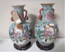 A pair of 20th century Chinese pottery vases on wooden stands
