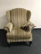 A wing back armchair upholstered in striped fabric