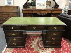 An oak twin pedestal desk with green tooled leather top,