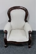 A Victorian style child's armchair upholstered in a cream striped fabric