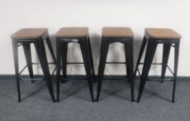 A set of four contemporary black metal wooden seated breakfast bar stools