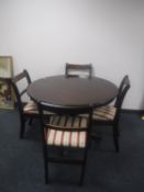 A circular inlaid mahogany Regency style pedestal dining table with four chairs