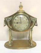 A French brass Art Nouveau mantel clock on raised legs, with key