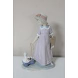 A Lladro figure of a girl pulling a doll in trolley