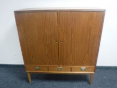 A Danish teak double door cupboard fitted three drawers