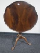 A mahogany pie-crust edge tilt topped occasional table on three way pedestal claw and ball feet
