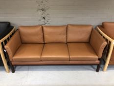 A late 20th century Danish stained beech three seater settee with brown leather cushions