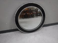 A contemporary circular black jewel framed mirror