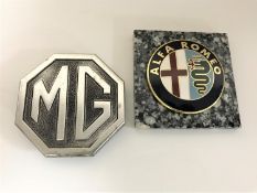 An MG car badge together with an Alfa Romeo car badge