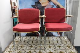 A pair of mid twentieth century Danish Dubra tubular metal and teak armchairs upholstered in a red